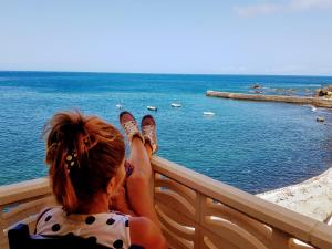 a woman sitting on a chair looking at the water at Vv Puesta de Sol in Alojera