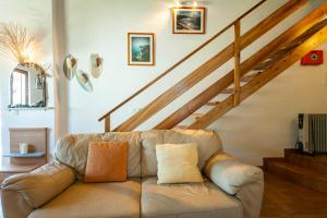 a leather couch in a living room with a staircase at H - Montes de Praias GuestHouse in Aljezur