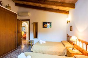 ein Hotelzimmer mit zwei Betten und einer Couch in der Unterkunft Villa MORENO in Pollença