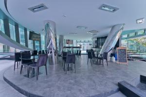 a dining room with tables and chairs in a building at TRENDY Studio in City Center Residence in Pattaya