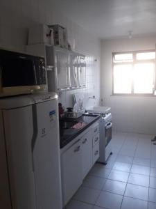 a kitchen with a white refrigerator and a stove at Dom Yargo II in Arraial do Cabo
