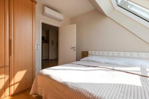 1 dormitorio con cama blanca y ventana en Großes Penthouse #12 mit Terrasse und Aussicht, en Viena
