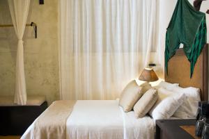 a bedroom with a bed with a lamp on it at Ya'ax Hotel Boutique in Mérida