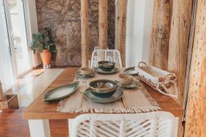 a table with plates and cups on top of it at Joy Beach House in São Pedro de Moel