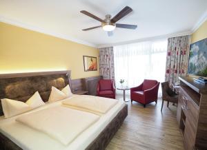 Schlafzimmer mit einem Bett und einem Deckenventilator in der Unterkunft Hotel Olympia in Bad Füssing