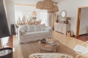 uma sala de estar com um sofá branco e uma mesa em Joy Beach House em São Pedro de Moel