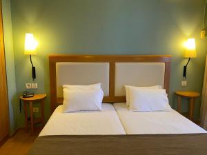 Postel nebo postele na pokoji v ubytování Olympic Hotel
