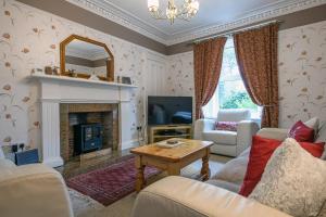 a living room with a fireplace and a mirror at Charming Townhouse on North Coast 500 Route, Wick in Wick