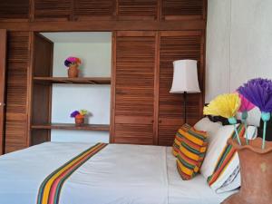 - une chambre avec un lit blanc et une tête de lit en bois dans l'établissement Hotel Casa Zoque Colonial, à Tuxtla Gutiérrez