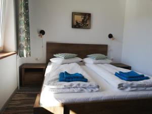 a bed with white sheets and blue pillows on it at Casa Ago - Guest House in Păuliş