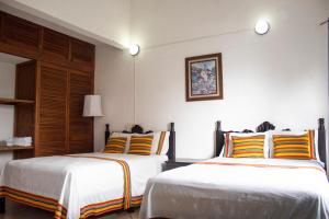 2 Betten in einem Hotelzimmer mit 2 in der Unterkunft Hotel Casa Zoque Colonial in Tuxtla Gutiérrez