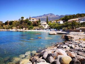 een strand met rotsen en huizen op de achtergrond bij Panos & Antzy Apartments in Kalamata