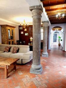 ein Wohnzimmer mit einem Sofa, einem Tisch und Säulen in der Unterkunft Casa Saltito in San Miguel de Allende