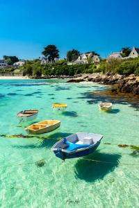 a group of boats in the water near a beach at Kermarco in Trégourez