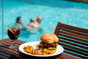a sandwich and chips on a table next to a glass of wine at Athineon Hotel in Rhodes Town