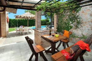 a patio with a table and chairs and an outdoor kitchen at Villa TIA in Pollença