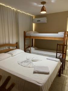 a room with two beds and two bunk beds at Pousada Galeão Pirata in Abrantes