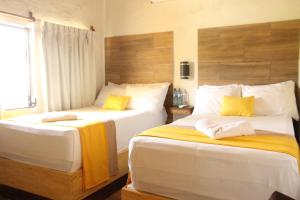 a bedroom with two beds with yellow pillows at Hotel Bahia del Sol in La Herradura +24 photos