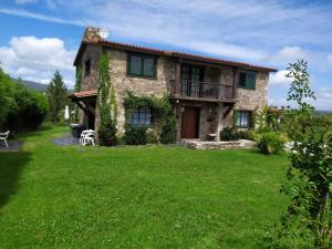 una casa de piedra con un césped verde delante de ella en Camiño da Vieira, en Padrón