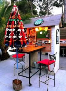 un bar esterno con tavolo, sedie e ombrellone di La Rustika Ontinyent a Ontinyent