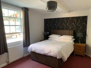 a bedroom with a bed and a large window at Castle Hotel in Devizes