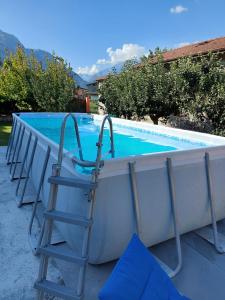 a pool with a ladder next to a bathtub at La casetta di Biancaneve Valtellina e lago di Como in Dubino