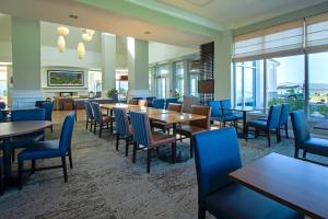 a restaurant with tables and chairs and windows at Shutters Hotel in Elko
