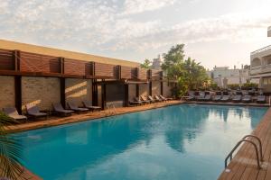 a swimming pool with lounge chairs on a building at Athineon Hotel in Rhodes Town