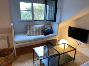 una pequeña sala de estar con sofá y TV en Ático en Tapia de Casariego con vistas a la playa., en Tapia de Casariego