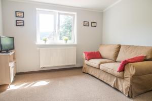 a living room with a couch and a television at Pension Rieger in Radošov