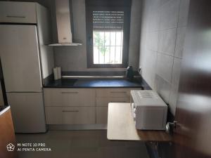 a kitchen with a white refrigerator and a window at Vivienda en El Centro de Guejar Sierra in Güéjar-Sierra +37 photos
