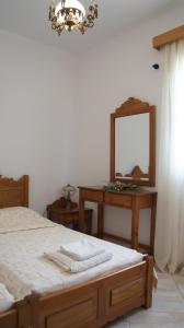 a bedroom with a bed and a dresser with a mirror at Pleiades Apartments in Lefkos Karpathou