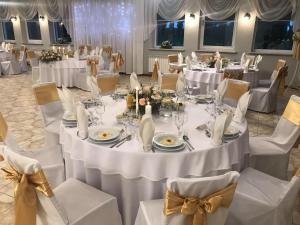 a ballroom with tables and chairs with white tablecloths at Hotel Wielkopolanka in Środa Wielkopolska