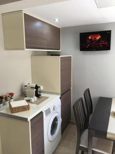 a kitchen with a washing machine and a table with chairs at Recién reformado casco histórico Alcalá de Henares in Alcalá de Henares