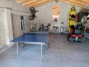 a ping pong table in a garage with bikes at Villa Katarina in Branik