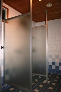 a metal door in a bathroom with a tile floor at Lohijärven Eräkeskus in Lohijärvi