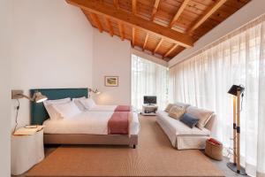 a bedroom with a bed and a couch at Cabanas da Viscondessa in Urzelina