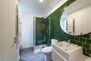a bathroom with a sink and a toilet and a mirror at Cabanas da Viscondessa in Urzelina