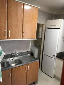 a kitchen with a sink and a white refrigerator at Vivienda en El Centro de Guejar Sierra in Güéjar-Sierra
