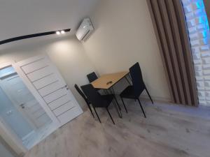 tavolo e sedie in una stanza con porta di Secheni Apartment a Užhorod