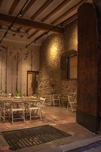 Habitación con mesas, sillas y pared de piedra. en La Casa Del Miracle, en Balaguer