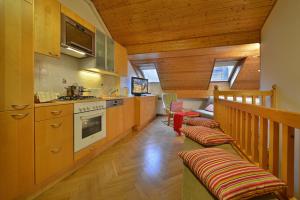 a kitchen with wooden cabinets and benches in a house at Old Town Apartments Tyn in Prague