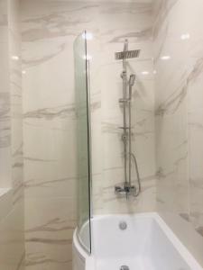 La salle de bains blanche est pourvue d'une douche et d'une baignoire. dans l'établissement Belvárosi Apartman 1, à Miskolc