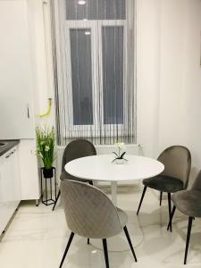 a white table and chairs in a room with a window at Belvárosi Apartman 1 in Miskolc