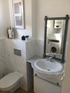 a bathroom with a sink and a toilet and a mirror at Widokówka in Tarnobrzeg
