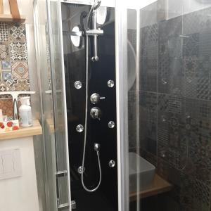 een douche met een glazen deur in de badkamer bij Beau studio refait a neuf centre ville avec clim balcon in Narbonne