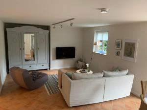 a living room with a white couch and a tv at Traumhafte Ferienwohnung nahe dem Nord-Ostsee-Kanal in Quarnbek