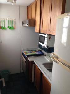 a small kitchen with a microwave and a counter top at Barra Beach in Rio de Janeiro