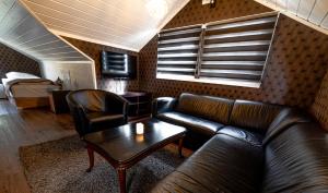 a living room with a couch and a table and a bed at HOTELLMILANO AS in Mosjøen