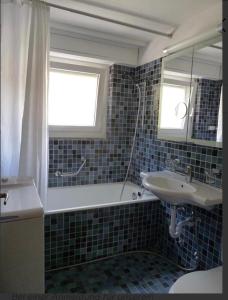 uma casa de banho com uma banheira e um lavatório em Eldorado 44 em Leukerbad